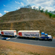 The General Motors Sunraycer solar-powered car drives alongside a road train trucking vehicle on Stuart Highway during the inaugural Darwin to Adelaide Pentax World Solar Challenge race on 10 November 1987 in the Northern Territories, Australia. (Photo by Simon Bruty/Getty Images)